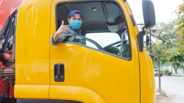 photos of truck drivers wearing masks to protect against dust and the spread of the flu. Covid 19. Inside the car front.